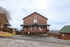 A wooden building with a porch and a small window, surrounded by a fence. - Time To Unwind (Sevierville)