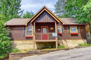 A log cabin with a front porch, a small entrance, and a sign indicating it is a lodge. - Twin Mountain (Sevierville)