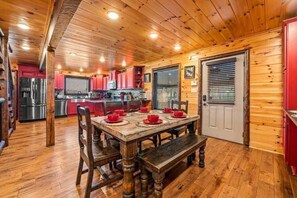 A wooden interior with a dining table set for six, kitchen cabinets, and a refrigerator. - Z - Walden's Creek Lodge (Sevierville)
