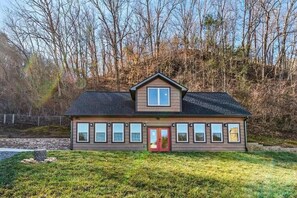 A two-story house with a red door, multiple windows, and a sloped roof. - Z - Walden's Creek Lodge (Sevierville)