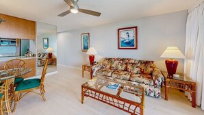 Una sala de estar con sofá, mesa de centro, mesa de comedor, sillas y lámparas.