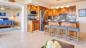 Eine moderne Küche mit Holzschränken, Edelstahlgeräten und einer Bar mit Sitzgelegenheiten.