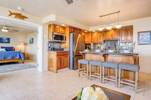 Eine moderne Küche mit Holzschränken, Edelstahlgeräten und einer Bar mit Sitzgelegenheiten.