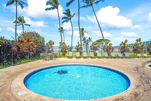 A swimming pool with a tiled edge, surrounded by a fence, palm trees, and lounge chairs. - NEW Fall Sale Ocean-View Kihei Penthouse for Sunset Stays (Kihei)