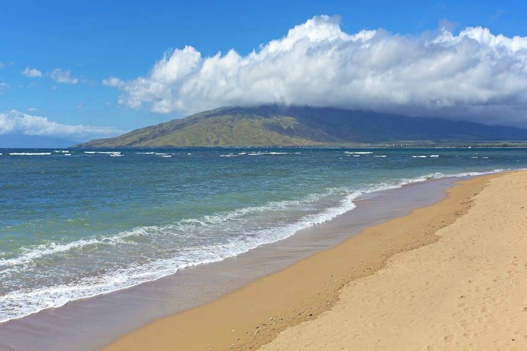 Una playa con una montaña al fondo.