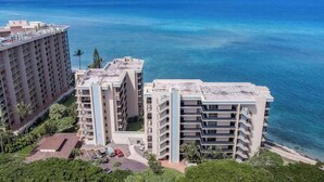 Een hoog hotel met meerdere verdiepingen en balkons, gelegen nabij een waterpartij onder heldere luchten.