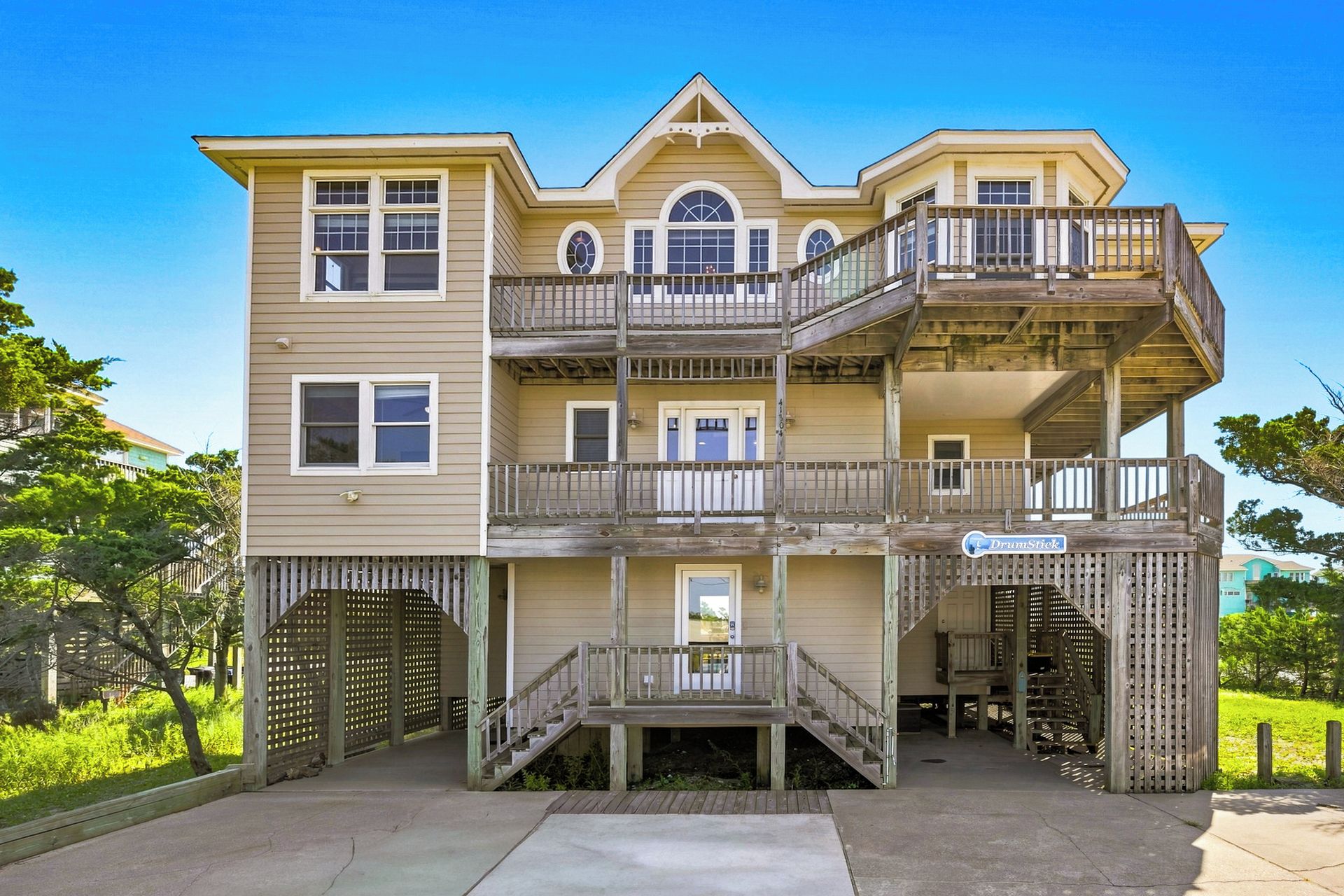 A multi-story building with a balcony, a staircase, and a gated entrance.