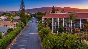 Un hôtel avec une longue allée, de nombreux balcons et une vue sur les montagnes.