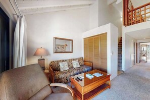 Ein Wohnzimmer mit einer Couch, einem Couchtisch, einer Lampe und einem Kleiderschrank.