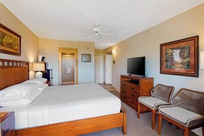 A hotel room with a bed, a television, a desk with a lamp, a chair, and a painting on the wall. - *NEW* Fall $pecial Two-Unit Kihei Retreat with Beach Access and Ocean Glimpse (Kihei)