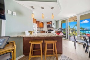 Eine moderne Küche mit Bar, großen Fenstern und Blick auf das Meer.