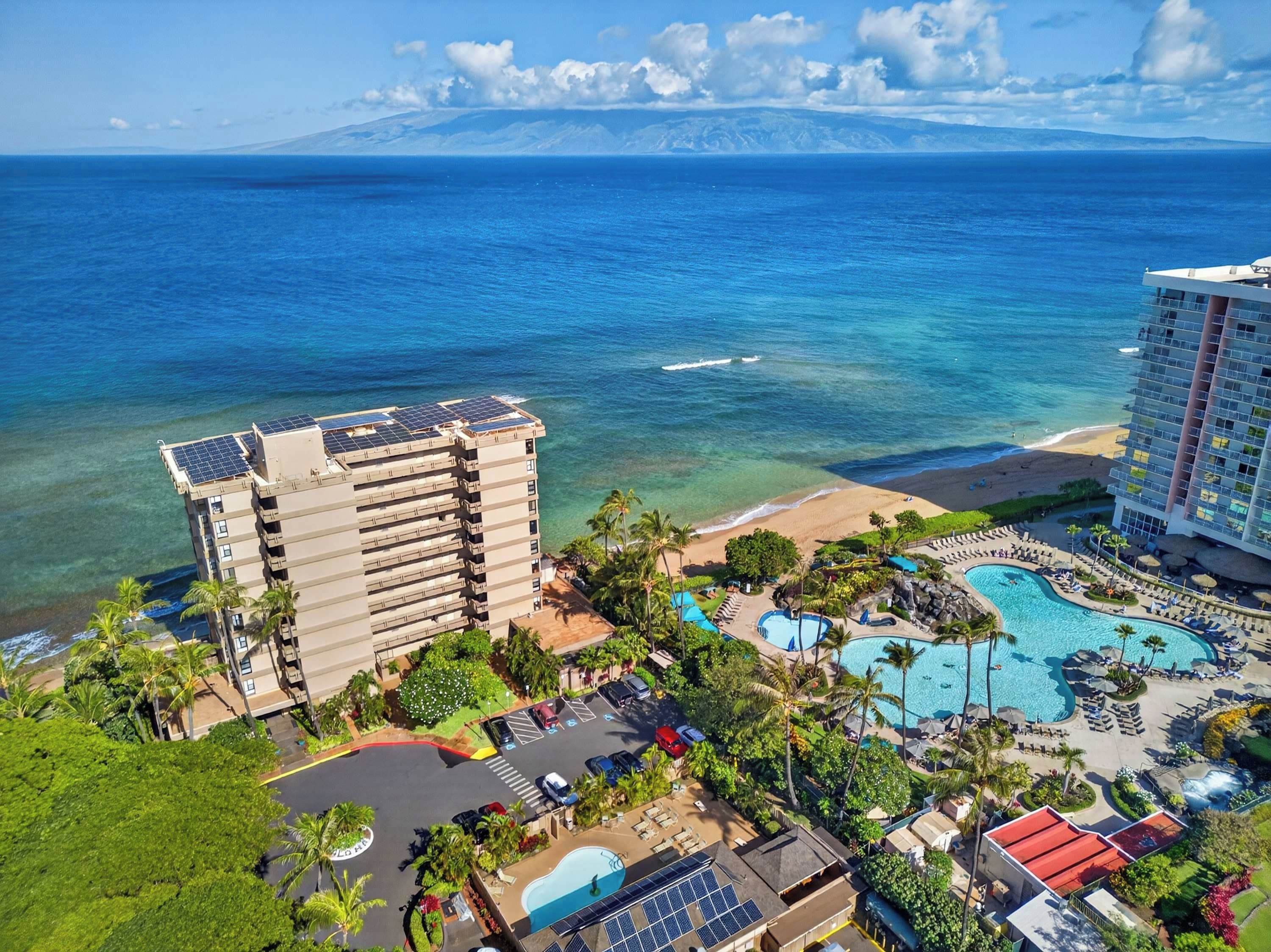 Un resort con zona de piscina, playa y vista al océano.