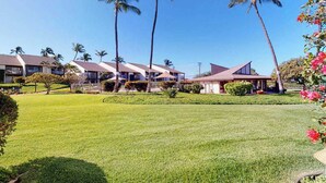 A hotel with multiple buildings, palm trees, and a well-maintained lawn. - *NEW* Fall Deal Kihei Condo for Four with Pools and Tennis by Kamaole III (Kihei)