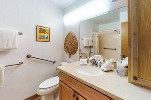 A bathroom with a toilet, sink, mirror, and a towel rack. - *New* Fall $ale Kamaole III Beach Days with a Kihei Lanai (Kihei)
