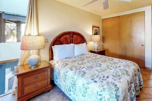 A bedroom with a bed, two bedside tables, a nightstand, a wooden wardrobe, and a ceiling fan. - *New* Fall $ale Kamaole III Beach Days with a Kihei Lanai (Kihei)