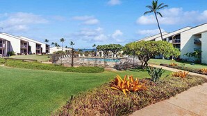 Un hôtel doté d’une piscine, de palmiers et offrant une vue sur un ciel dégagé.
