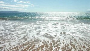 Ein Strand mit Wellen und blauem Himmel.