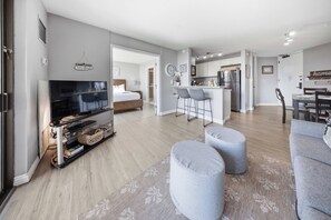 Un apartamento moderno con sala de estar, comedor, cocina y un dormitorio.