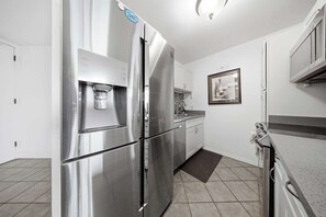 A modern kitchen with stainless steel appliances, a water dispenser, and a sink. - *New* Beachfront Kihei Condo near Pickleball and Pool (Kihei)