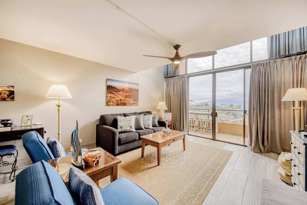 Uma sala de estar moderna com sofá, mesa de centro e uma grande janela com cortinas.