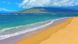 A beach with clear water, a sandy shore, and a mountain in the background. - New Kihei Ocean-View Retreat for Two with Beachfront Pool (Kihei)