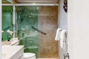Une salle de bain moderne avec une douche à parois de verre, des toilettes et un lavabo avec un miroir.