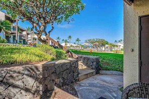 A stone pathway leading to a building, a tree, and a well-maintained lawn. - New Fall Sale Ground-Floor Kihei Couple's Escape by Kamaole III (Kihei)
