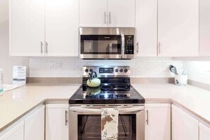 A kitchen with stainless steel appliances, white cabinets, and a tiled backsplash. - *New* Fall $pecial A Family-Friendly South Kihei Stay Near Kamaole III (Kihei)
