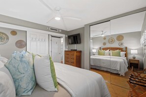 Une chambre d’hôtel équipée d’un lit, d’une télévision, d’une armoire et d’un miroir.