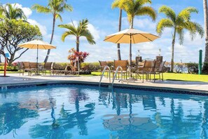 A swimming pool with lounge chairs and umbrellas, surrounded by palm trees and a clear sky. - NEW Fall Sale 7th-Floor Mountain-View Retreat at Lahaina Shores (Lahaina)