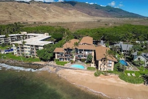 Ein Küstenhotel mit mehreren Gebäuden, einem Schwimmbad und einem Strand.