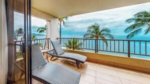 Ein Balkon mit zwei Korstühlen und Blick auf das Meer.