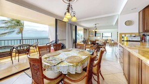 Ein geräumiger Essbereich mit Meerblick, eine Küche mit Holzschränken und ein Balkon mit Korbmöbeln.