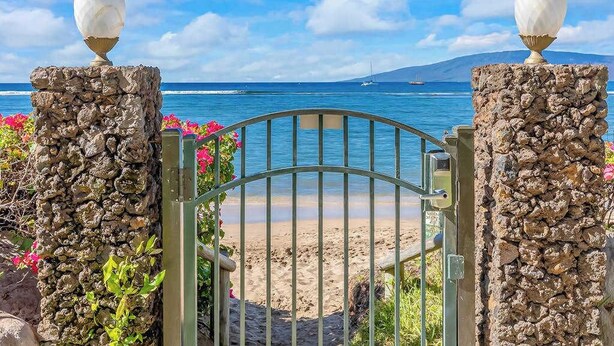 Una puerta de acceso a la playa, con vistas al océano y una isla distante.