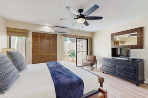A bedroom with a bed, a ceiling fan, a dresser, a television, and a sliding glass door leading to an outdoor area. - *New* Updated Kihei Condo with Two Private Patios (Kihei)