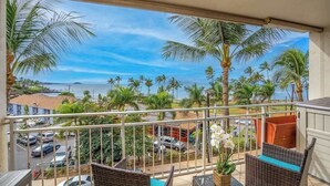 A balcony with wicker furniture, a view of the ocean, and palm trees. - *NEW* Fall $ale Ocean-View Kihei Escape Steps from The Cove (Kihei)