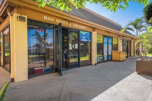 A building with a sign reading 'MAUI SIGHTS & TREASURES' and another sign for 'SNORKELING RENTALS & SALES'. - Beachfront Sugar Beach Days in North Kihei (Kihei)