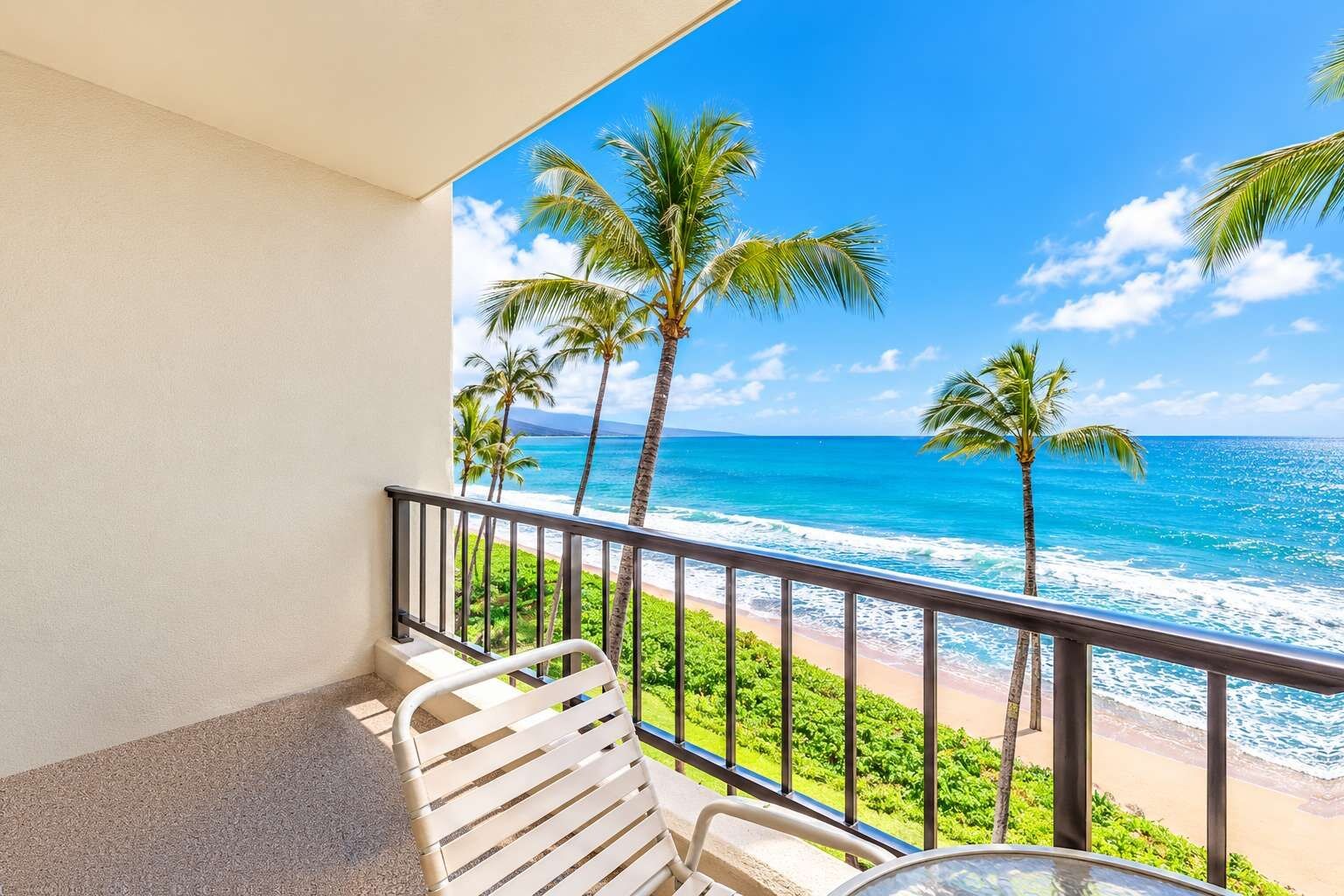 A balcony with a view of the ocean, palm trees, and a beach.