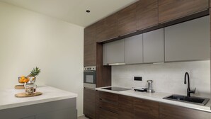 Eine moderne Küche mit Holzschränken, einer Edelstahl-Spüle und einem eingebauten Backofen.