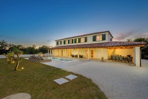 Ein modernes Haus mit Swimmingpool, Sitzgelegenheit im Freien und einer Terrassenfläche.