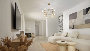 Uma sala de estar moderna com sofá, mesa de centro e plantas decorativas.
