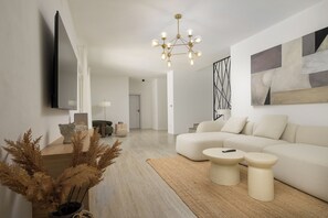 Ein stilvolles Wohnzimmer mit einer Couch, einem Couchtisch und dekorativen Pflanzen.