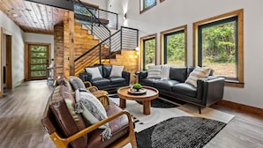 Ein geräumiger Wohnbereich mit Treppe, großen Fenstern und modernem Design.
