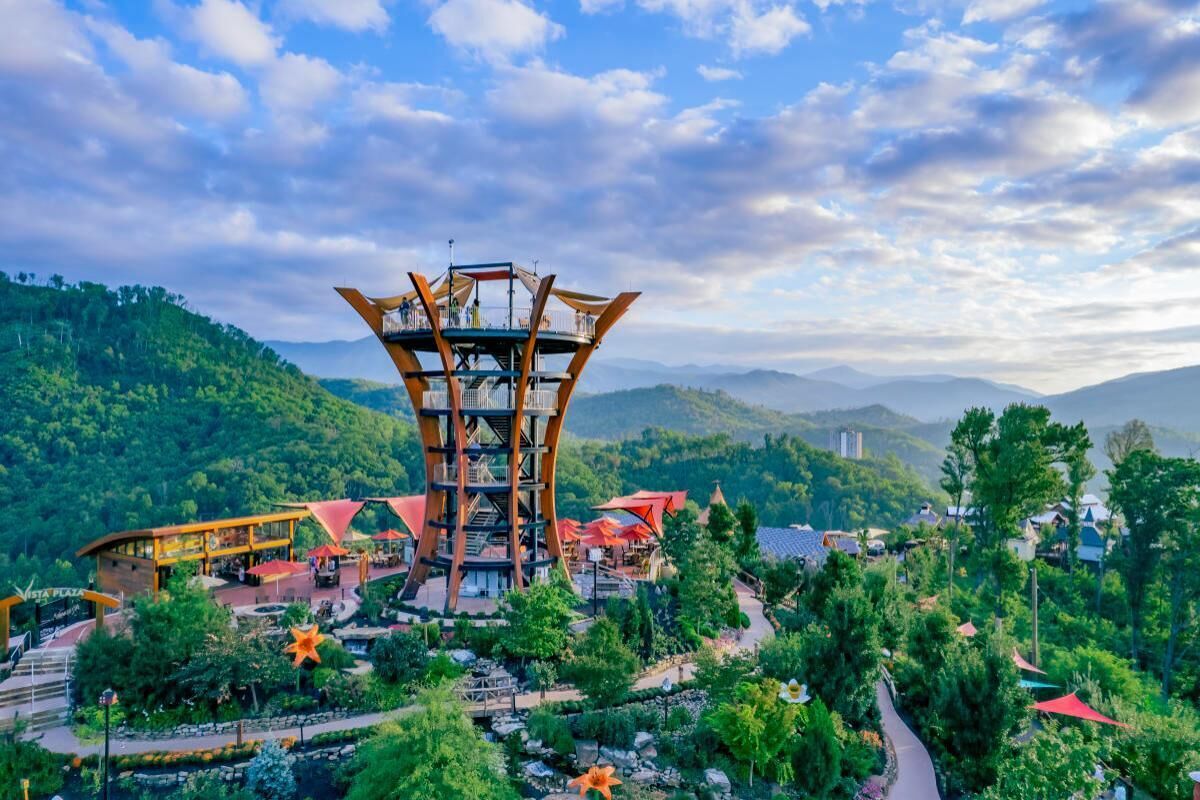 A multi-level tower structure with a central staircase, surrounded by lush greenery and a winding path.