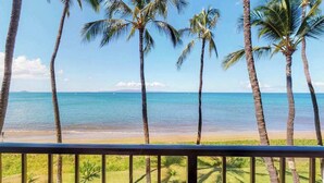 Blick auf einen Strand mit Palmen und blauem Himmel.