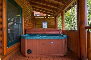 A wooden cabin with a hot tub, a safety notice, and a window. - Mountain Sunrise (Sevierville)