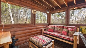A wooden cabin interior with a sofa, a small table, and a bear figurine. - Fox n' Socks (Sevierville)