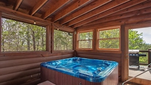 A wooden cabin with a hot tub, large windows, and a deck. - Fox n' Socks (Sevierville)