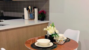 Una cocina compacta con microondas, armarios y un comedor con mesa y sillas.