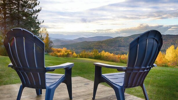 Two Adirondack chairs on a wooden deck with a view of a mountainous landscape. - Enjoy stunning view in Waterville Estates! (Thornton)